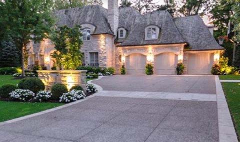 A large house with a spacious aggregated concrete driveway and walkway.